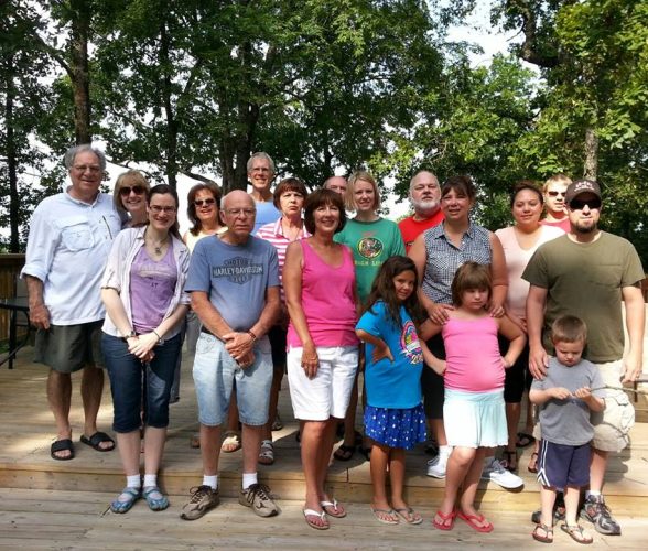 Large family group posing together on wooden deck surrounded by trees at Foxfire Resort On Table Rock Lake